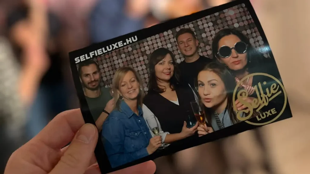Egy kinyomtatott SelfieLuxe fotó, amin egy csoport nő és férfi pózol